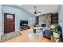 Inviting living room features a stone fireplace, hardwood floors, vaulted ceiling, and a large bay window at 15835 E Oxford Ave, Aurora, CO 80013