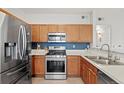 Kitchen featuring stainless steel appliances, wooden cabinets, and light countertops at 9961 E Idaho Cir # 104, Aurora, CO 80247