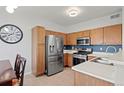 Bright kitchen featuring stainless steel appliances and wooden cabinets near a dining table at 9961 E Idaho Cir # 104, Aurora, CO 80247