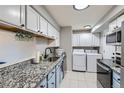 Efficient kitchen featuring modern appliances, granite countertops, and convenient laundry area at 62 Newark St # C, Aurora, CO 80012