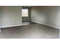 Bright living room featuring neutral paint, soft carpet, and large windows, creating a welcoming and relaxing atmosphere at 405 Dogwood Ave, Brighton, CO 80601