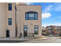 Modern building exterior with clean lines, an arched window, and a small front patio at 4625 W 50Th Ave # 110, Denver, CO 80212