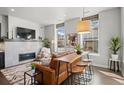 Modern living room showcasing a fireplace, stylish seating, and a unique bar-height table with stools at 4625 W 50Th Ave # 110, Denver, CO 80212