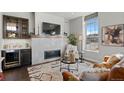 Inviting living room with a fireplace, TV, display shelving, and comfortable seating by a large window at 4625 W 50Th Ave # 110, Denver, CO 80212