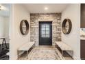 Inviting entryway with stone accent wall, decorative mirrors, tile flooring, and bench seating at 15280 Bannock St, Broomfield, CO 80023