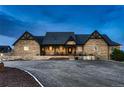 Stone-clad home featuring a welcoming front porch, accented with black trim and a charming facade for inviting curb appeal at 15280 Bannock St, Broomfield, CO 80023