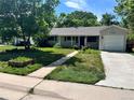 Attractive single-story home featuring a tidy front yard and convenient attached garage at 3353 S Glencoe St, Denver, CO 80222