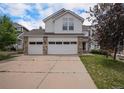 Daytime view of a two-story home with a three-car garage and brick accents, complemented by a well-manicured lawn at 5755 S Zante Cir, Aurora, CO 80015