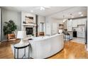 Cozy living room features a white sofa, fireplace, and view into the kitchen at 199 Quebec St # M, Denver, CO 80220