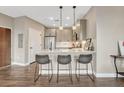 A modern kitchen features stainless steel appliances, pendant lighting, and an eat-in bar with seating at 2729 W 28Th Ave # 401, Denver, CO 80211
