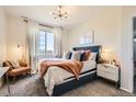 Bright bedroom showcases a large window with scenic views, a plush bed with decorative pillows, and stylish nightstand at 5255 Memphis St # 311, Denver, CO 80239
