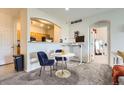 Cozy dining area features a round table with blue chairs, complemented by an adjacent workspace and partial kitchen view at 5255 Memphis St # 311, Denver, CO 80239