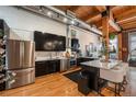 Modern kitchen featuring stainless steel appliances, a kitchen island and sleek black cabinetry at 2955 Inca St # 2L, Denver, CO 80202