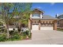 Inviting two-story home with well-manicured landscaping, a three-car garage, and brick and siding accents at 7132 S Tempe Ct, Aurora, CO 80016