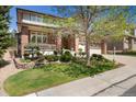 Beautifully landscaped front yard with mature trees and a well-maintained lawn leading up to the home at 7132 S Tempe Ct, Aurora, CO 80016