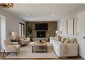 Bright living room featuring a stone fireplace, modern furniture, and contemporary art at 7753 W Plymouth S Pl, Littleton, CO 80128
