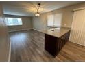 Open-concept living and dining area with hardwood floors and a modern light fixture at 3038 S Xenia Ct, Denver, CO 80231