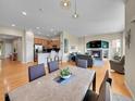 Open-concept living and dining area with hardwood floors, fireplace, and modern furnishings at 5309 W Hoover Dr, Littleton, CO 80123