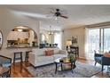 Inviting living room with hardwood floors, ceiling fan, and open view to the adjacent kitchen and dining area at 8450 Everett Way # D, Arvada, CO 80005