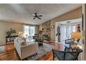 Comfortable living room featuring a stone fireplace, ceiling fan, and sliding doors to the outside at 8450 Everett Way # D, Arvada, CO 80005