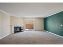 Inviting living room with a fireplace, neutral carpet, and sliding door access to the outside at 3332 S Ammons St # 103, Lakewood, CO 80227