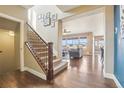 Open staircase with hardwood floors leading to a sun-filled living room at 311 Portmeirion Ln, Castle Rock, CO 80104