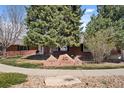 Brick home featuring mature trees, stone community markers, and well-maintained landscaping at 5425 County Road 32 # 14, Mead, CO 80504