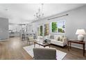 Bright, open living room featuring hardwood floors, modern chandelier, and access to outdoor space at 3775 Balderas St, Brighton, CO 80601