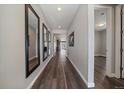 Inviting home hallway with wood floors, decorative mirrors, and views of the living area at 5611 Saddle Skirt St, Parker, CO 80134