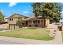 Landscaped front yard with mature trees accenting this beautiful home's brick and siding exterior with sidewalk access at 2160 S Flower St, Lakewood, CO 80227