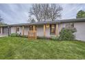 Inviting home exterior featuring a manicured lawn, fresh landscaping, and charming wooden accents at 10698 W 26Th Ave, Lakewood, CO 80215