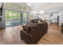 Bright, open-concept living room with hardwood floors, access to the kitchen, and views of the outdoors at 4121 River Oaks St, Castle Rock, CO 80104