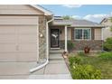 Front of house with stone accents, landscaped yard, and covered front porch at 12753 Buckhorn Creek St, Parker, CO 80134