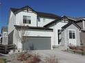 Charming two-story home featuring a stone facade, gray garage door, and well-maintained landscaping at 5223 Gray Wolf Ln, Castle Rock, CO 80104