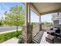 Inviting front porch with comfortable seating and decorative brick columns, perfect for relaxing outdoors at 2090 Bellavista St, Castle Rock, CO 80109