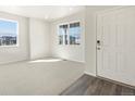 Open living area featuring carpet, large windows providing natural light and neutral paint at 9089 Pitkin St, Commerce City, CO 80022