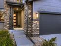 Close-up of home entrance with stone pillars and a modern front door, number 10968 to the right at 10968 Pastel Pt, Parker, CO 80134