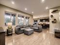 Open-concept living room with a large gray sectional, wood floors, and abundant natural light at 10968 Pastel Pt, Parker, CO 80134