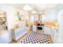 Efficient kitchen with white cabinetry, stainless steel appliances, and checkered flooring at 2548 S Zurich Ct, Denver, CO 80219
