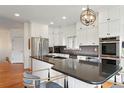 Modern kitchen features stainless steel appliances, sleek countertops, white cabinetry, and a stylish breakfast bar at 4212 E Orchard Pl, Centennial, CO 80121