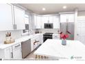 Bright kitchen features white cabinets, stainless steel appliances, and white marble countertops at 1577 W 166Th Ave, Broomfield, CO 80023