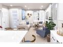 Bright living room featuring white sofas with blue pillows, recessed lighting, and modern wall decor at 1577 W 166Th Ave, Broomfield, CO 80023