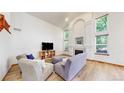 Airy living room with a fireplace, lots of natural light, and hardwood floors, making it the perfect space to relax and unwind at 13673 Cook St, Thornton, CO 80602