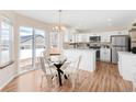 Eat-in kitchen with bright white cabinets, stainless appliances, and sliding glass door to the back yard at 205 Hawthorn St, Frederick, CO 80530