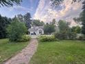 A stone walkway leads to this home with mature trees and a well-manicured lawn at 6375 E 6Th Avenue Pkwy, Denver, CO 80220