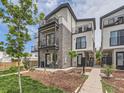 Striking multi-story home with stone accents, multiple balconies, and professionally landscaped yard at 1472 Yates St, Denver, CO 80204