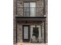 Close-up of a home's entrance with stone accents, black trim, and an inviting outdoor seating area at 1472 Yates St, Denver, CO 80204