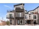 Modern townhomes featuring stacked balconies, stone facade accents, and contemporary design at 1472 Yates St, Denver, CO 80204