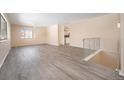 Open living room with gray vinyl flooring and a staircase at 1832 Simms St, Lakewood, CO 80215