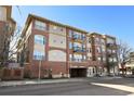 Chamberlin Heights showcasing the red brick facade, multiple balconies, and convenient underground parking at 1489 Steele St # 310, Denver, CO 80206